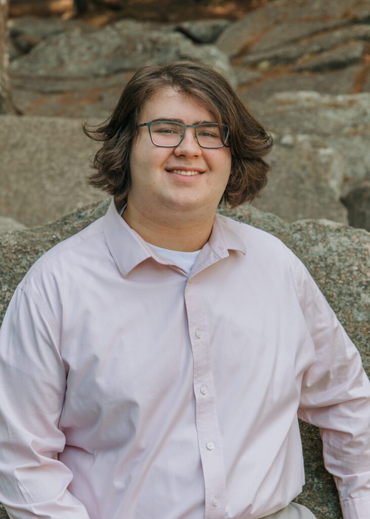 Student smiling in Senior portrait photography session in Purgatory Chasm, Greater Boston, Massachusetts.