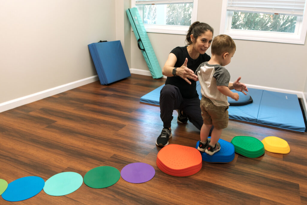 Jenna of Raheb Physical Therapy guiding child patient in exercises.